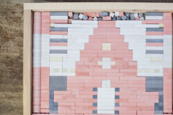 Blick in eine KINGSTONES Holzkasten mit vielen verschiedenen Steine, die bereits ein Gebäude erkennen lassen